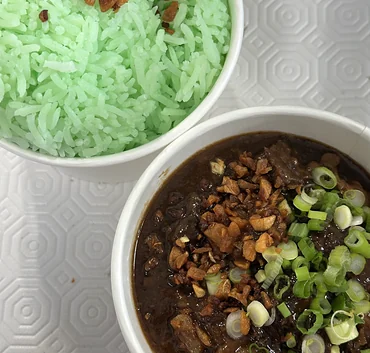 Beef pares with fried garlic and scallions next to pandan rice